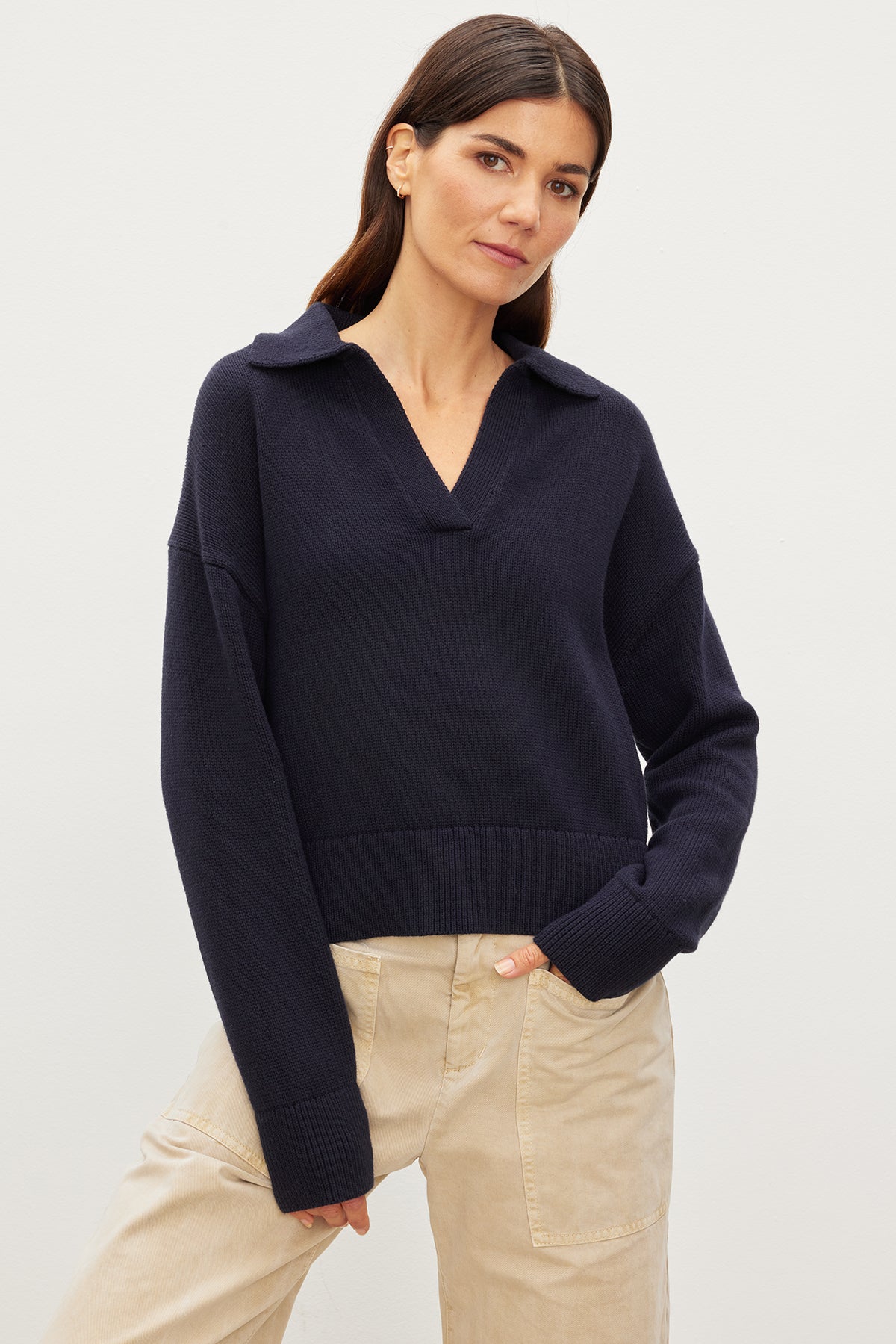   A woman in a Velvet by Graham & Spencer Lucie Polo Sweater made of cotton. 