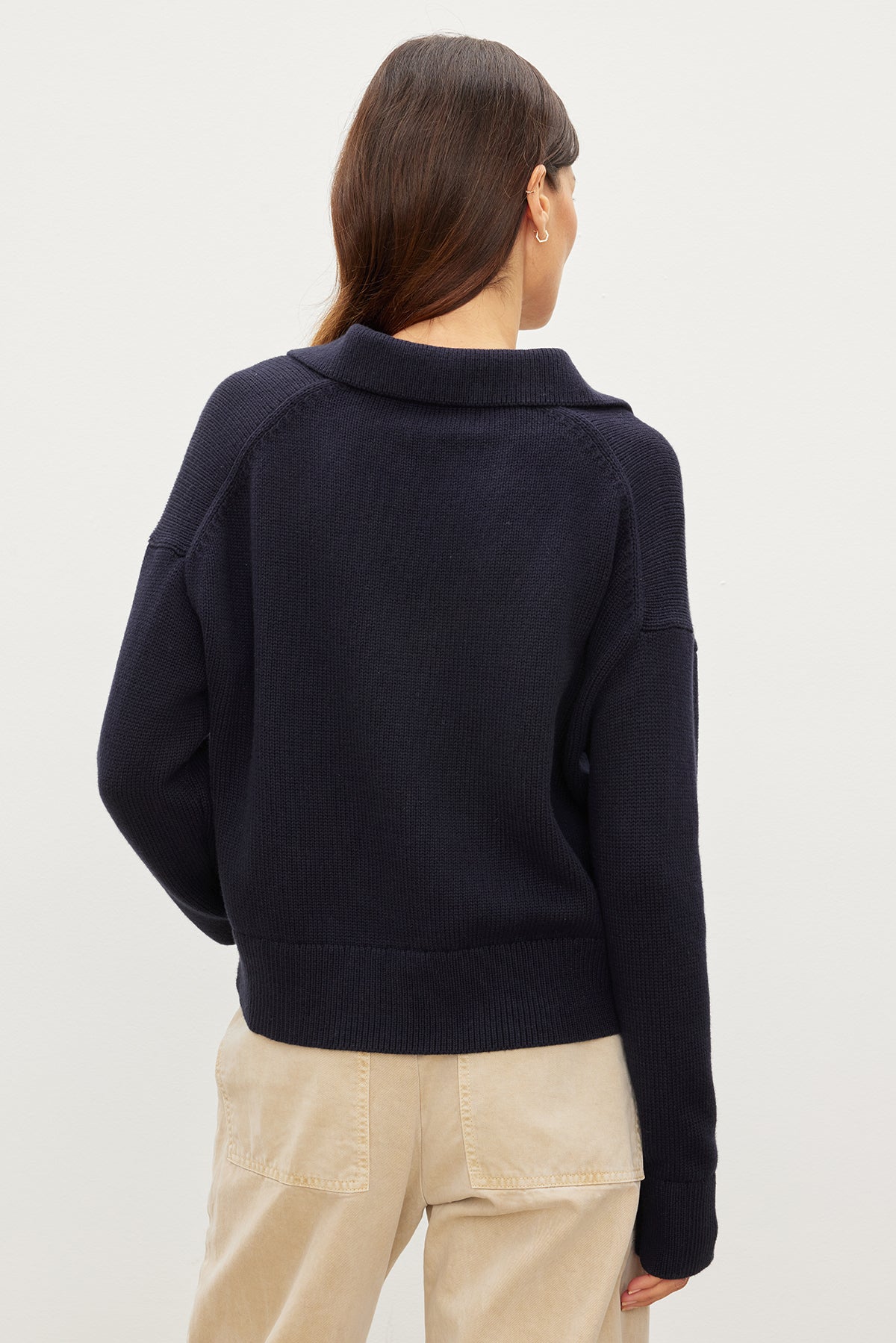   A woman in a LUCIE POLO SWEATER made of cotton/cashmere material, by Velvet by Graham & Spencer. 