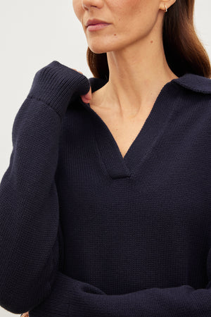 A woman wearing a Velvet by Graham & Spencer LUCIE POLO SWEATER made of cotton/cashmere.