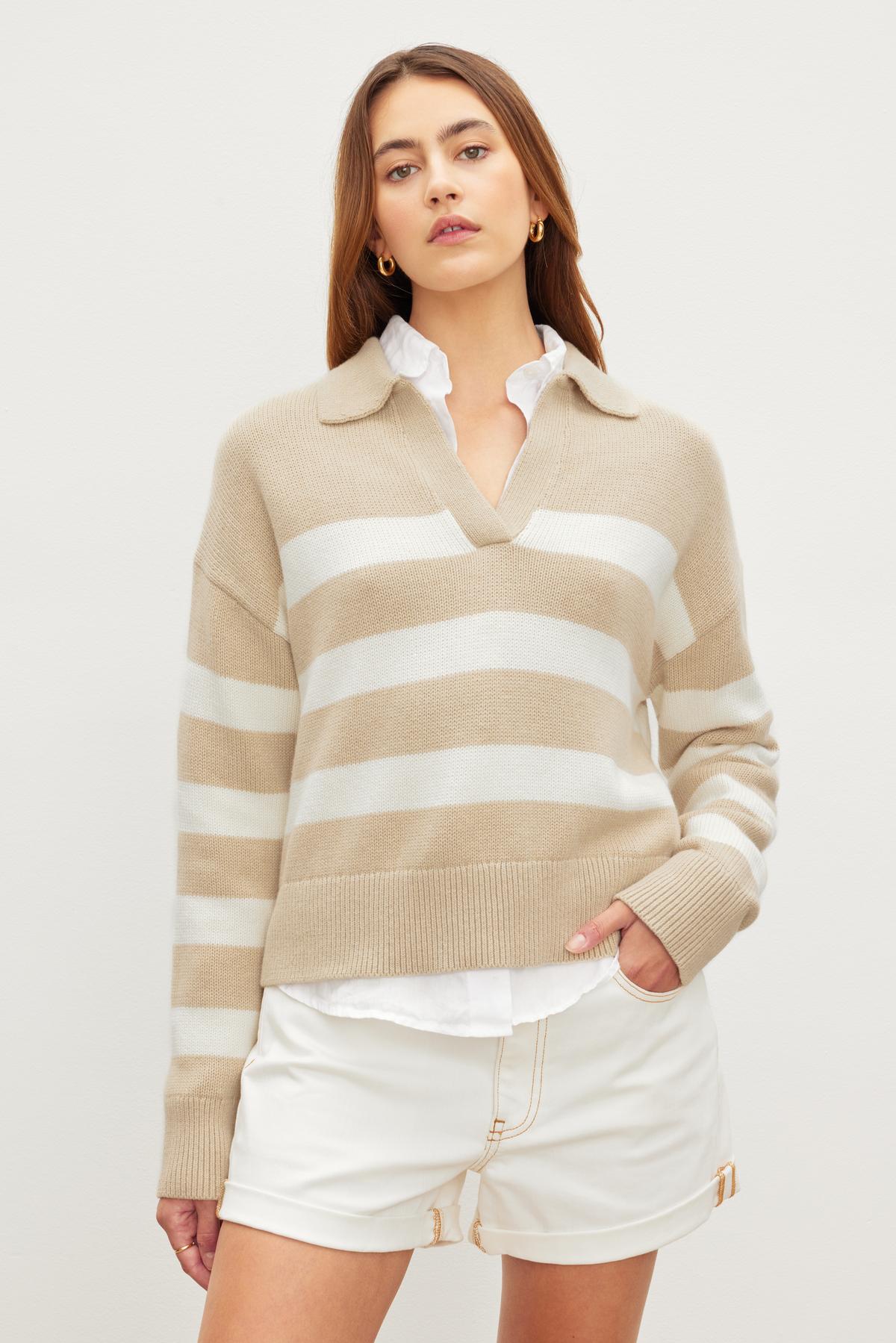 The model is wearing a beige LUCIE POLO SWEATER by Velvet by Graham & Spencer and white shorts made of a cotton/cashmere blend.-36248057970881