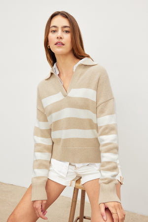 The model is wearing a beige Velvet by Graham & Spencer LUCIE POLO SWEATER.