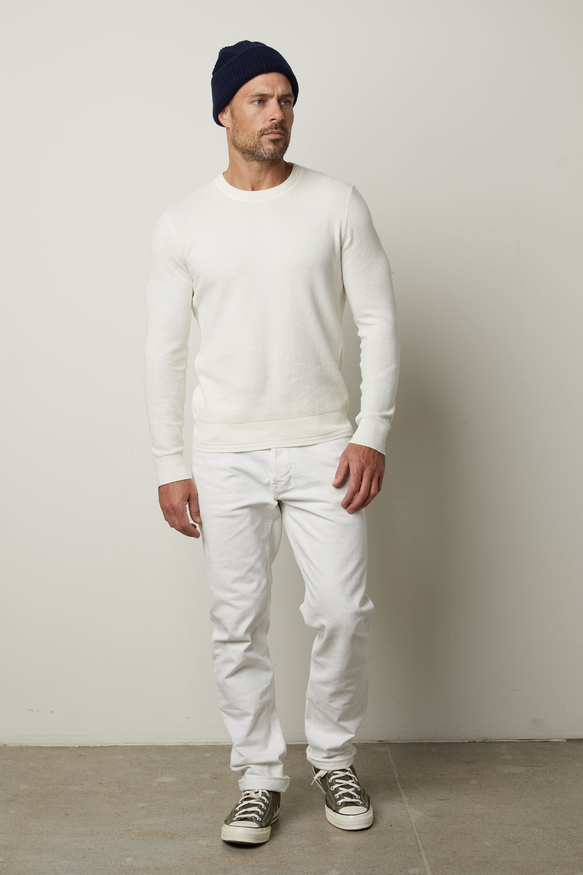   A man wearing a Velvet by Graham & Spencer WALTER CREW NECK SWEATER and jeans. 