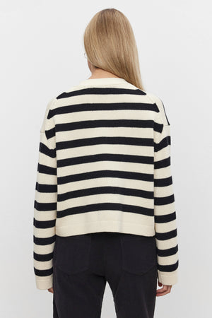 Person with long blonde hair wearing the ELODIE CARDIGAN by Velvet by Graham & Spencer, paired with black pants, facing away from the camera against a plain white background.