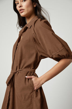 The model is wearing a KADY CORDUROY BUTTON-UP DRESS by Velvet by Graham & Spencer.