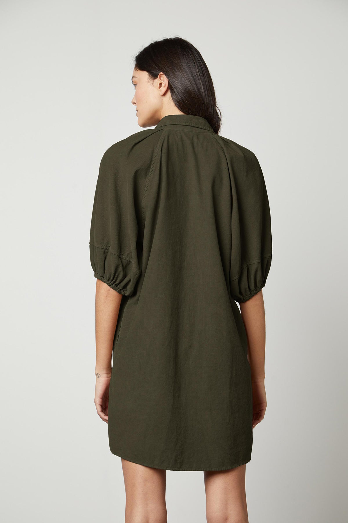 The back view of a woman wearing a KADY CORDUROY BUTTON-UP DRESS, perfect for everyday wear.-26921328672961