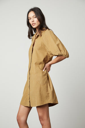 The model is wearing a KADY CORDUROY BUTTON-UP DRESS by Velvet by Graham & Spencer.