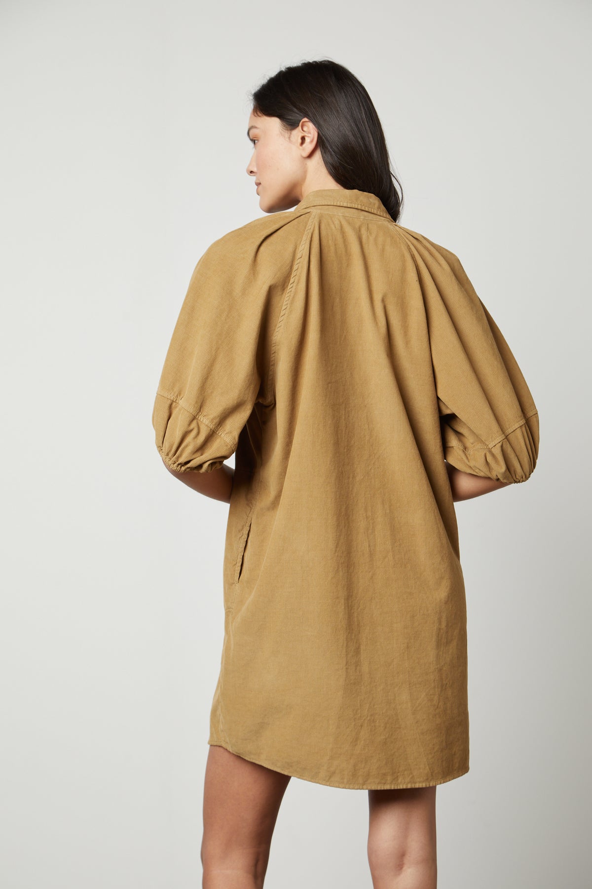 The back view of a woman wearing a Velvet by Graham & Spencer KADY CORDUROY BUTTON-UP DRESS.-26727742079169