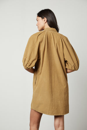 The back view of a woman wearing a Velvet by Graham & Spencer KADY CORDUROY BUTTON-UP DRESS.