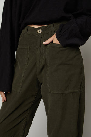 A woman wearing a black top and SUE CORDUROY PANT by Velvet by Graham & Spencer.