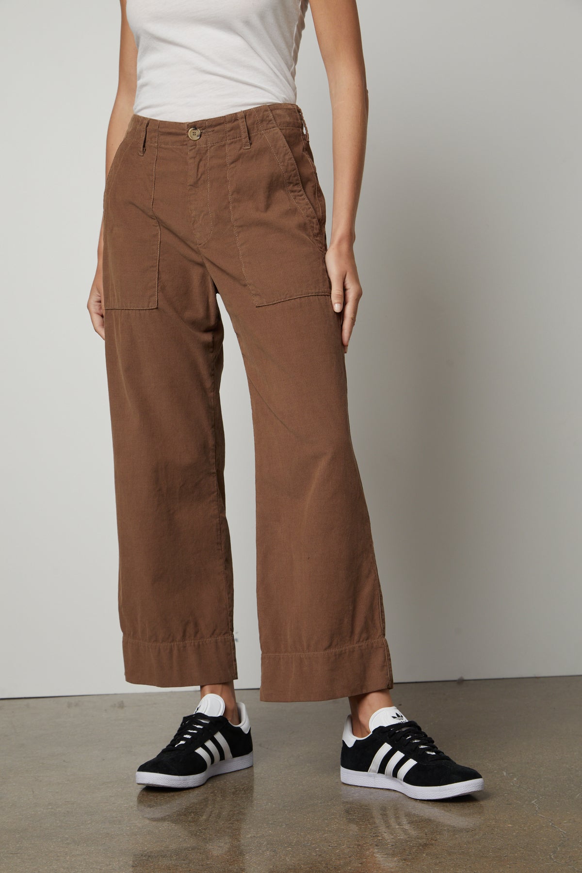 A woman wearing Velvet by Graham & Spencer's VERA CORDUROY WIDE LEG PANT and white sneakers.-26914938585281