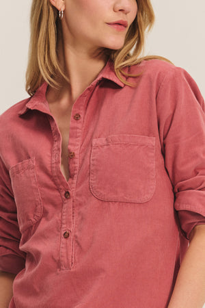 A woman wears the ARIELLE CORDUROY SHIRT by Velvet by Graham & Spencer in rose pincord with rolled-up sleeves, shown from shoulders to mid-torso—a perfect fall staple.