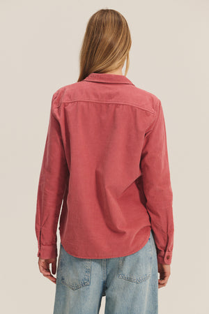 A person with long light brown hair, seen from behind against a plain background, wears the ARIELLE CORDUROY SHIRT by Velvet by Graham & Spencer with light blue jeans—a fall essential.