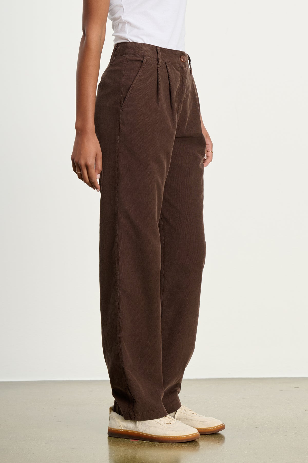 A person stands against a plain light background wearing a white T-shirt, beige shoes, and Velvet by Graham & Spencer's GAIL CORDUROY PANT in relaxed cotton corduroy.-39617449066689