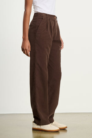 A person stands against a plain light background wearing a white T-shirt, beige shoes, and Velvet by Graham & Spencer's GAIL CORDUROY PANT in relaxed cotton corduroy.