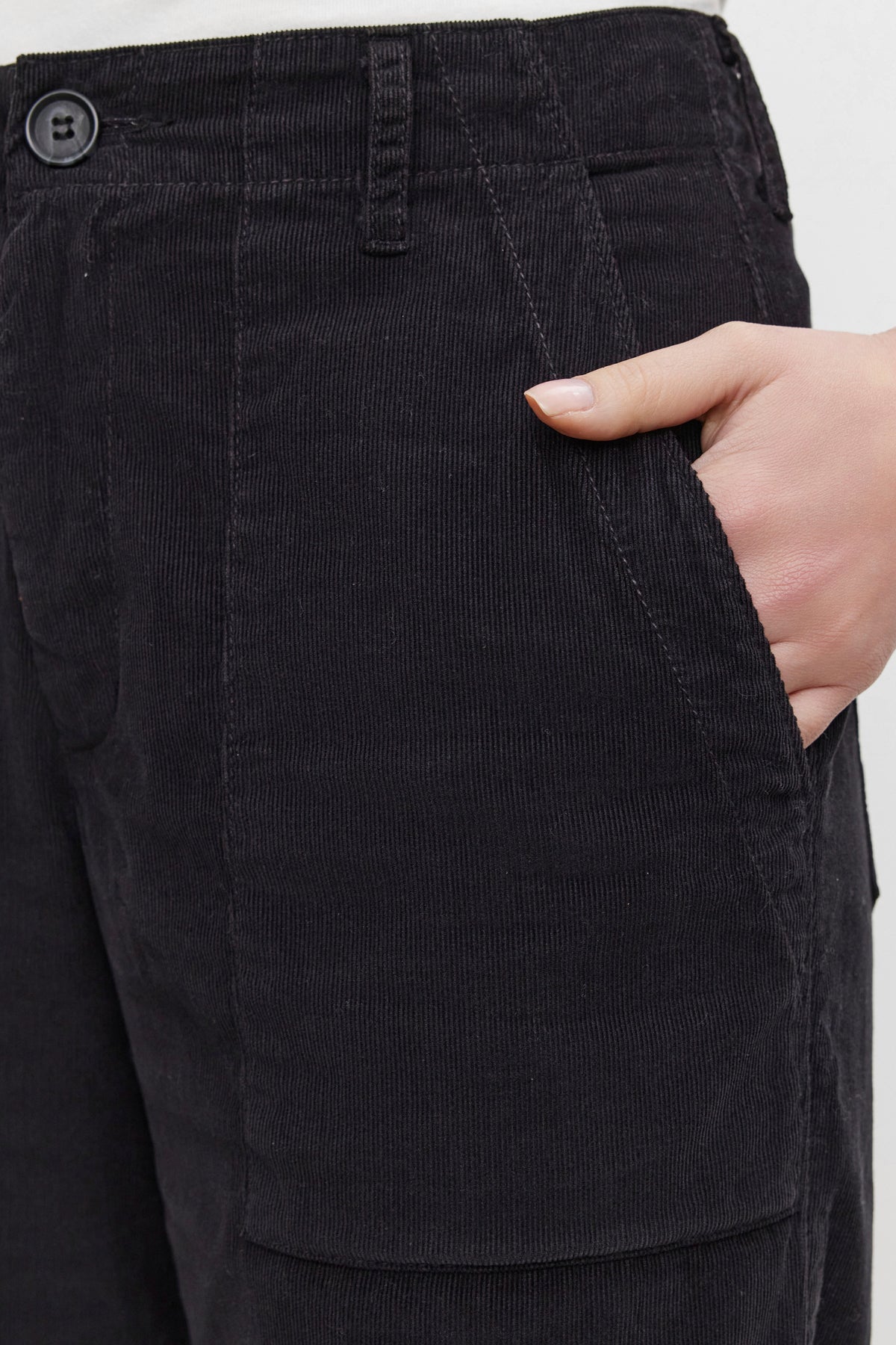   A person wearing the VERA CORDUROY PANT by Velvet by Graham & Spencer places their right hand in a front pocket, showcasing a flattering silhouette. 