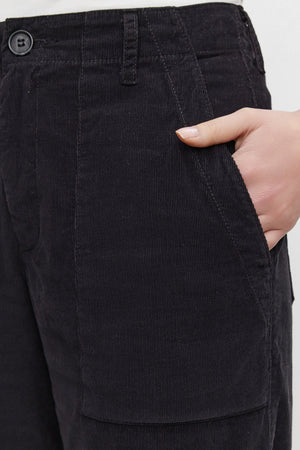 A person wearing the VERA CORDUROY PANT by Velvet by Graham & Spencer places their right hand in a front pocket, showcasing a flattering silhouette.