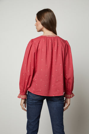 The boho vibe of a woman wearing the ANIA EMBROIDERED BOHO TOP by Velvet by Graham & Spencer can be seen from the back view.