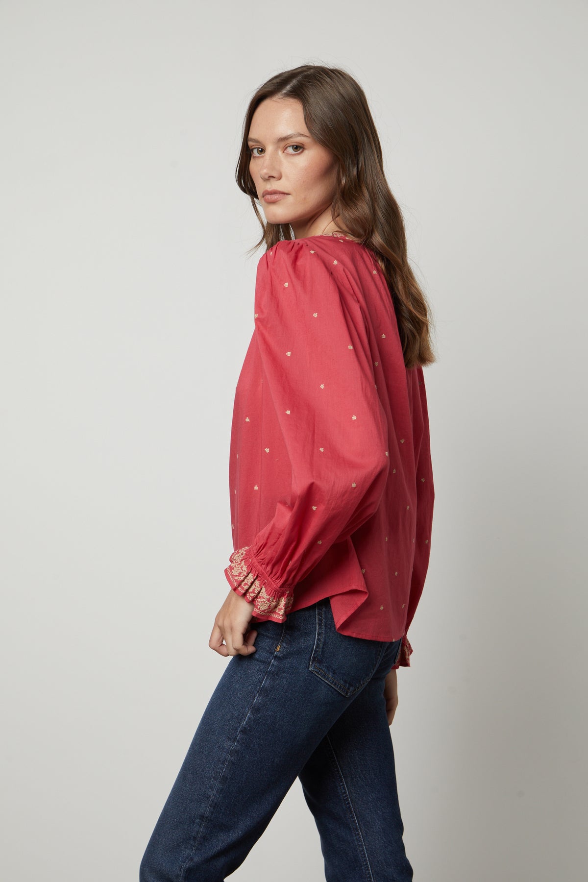   The model is wearing a red ANIA EMBROIDERED BOHO TOP by Velvet by Graham & Spencer, giving off a boho vibe. 