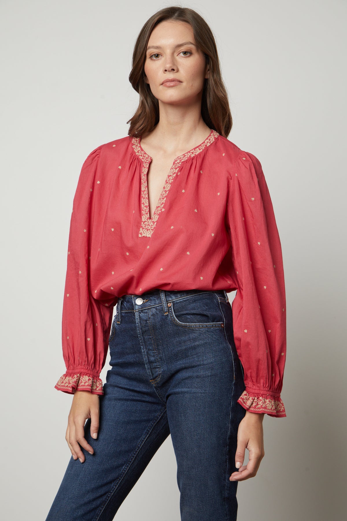   The model is wearing jeans and a red blouse with Velvet by Graham & Spencer's ANIA EMBROIDERED BOHO TOP. 