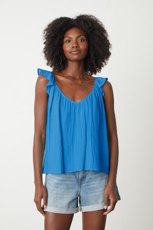 The model is wearing an ANETTE COTTON GAUZE TOP by Velvet by Graham & Spencer with ruffled sleeves.