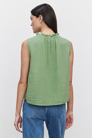 A woman seen from behind wearing a Velvet by Graham & Spencer BIANCA COTTON GAUZE TANK TOP with an elastic neckline and blue jeans.