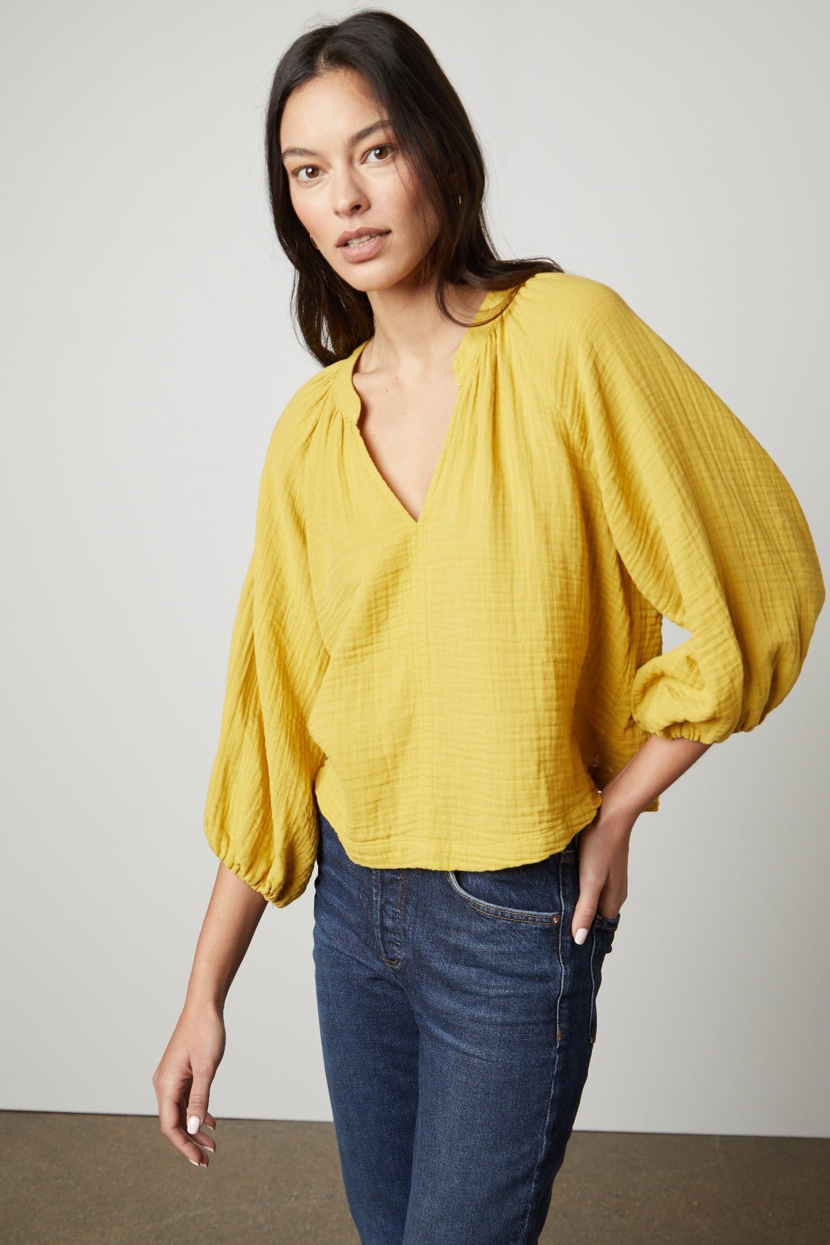 The model is wearing a yellow CARLA COTTON GAUZE TOP with sleeve ruffles by Velvet by Graham & Spencer.-26727052050625