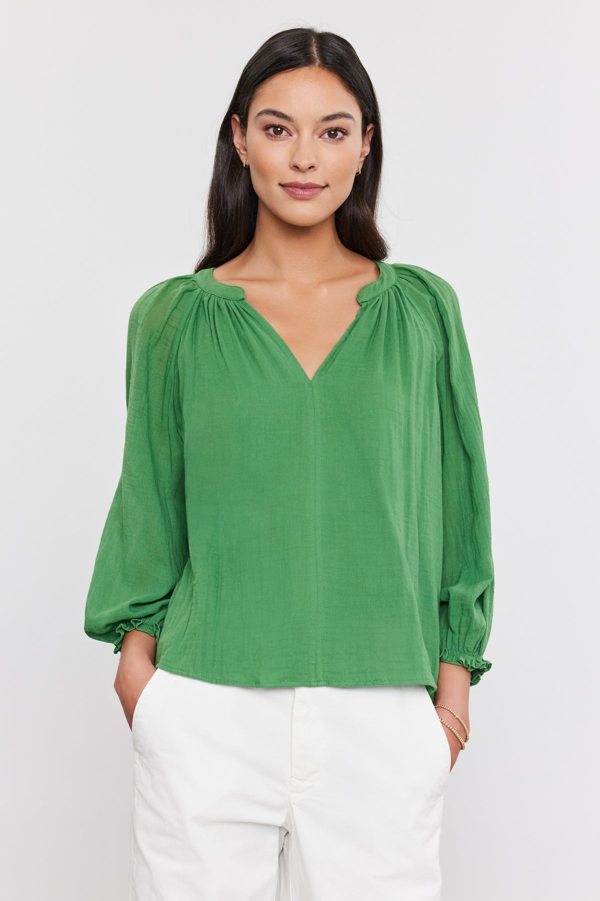   A woman in a Denice Cotton Gauze Top by Velvet by Graham & Spencer with sheer sleeves and white pants posing against a white background. 