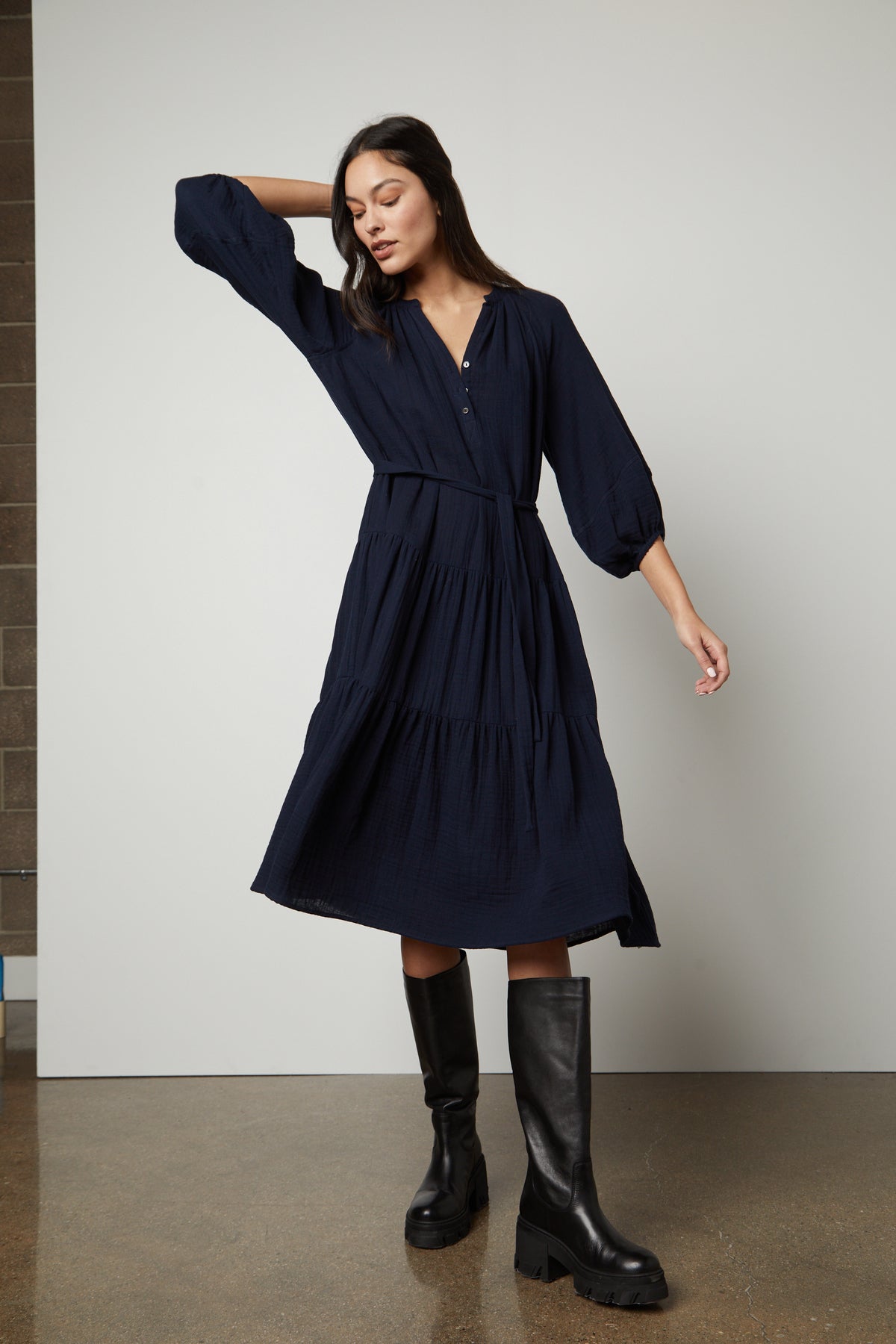  The model is wearing a Velvet by Graham & Spencer DIXON COTTON GAUZE TIERED DRESS and black boots. 