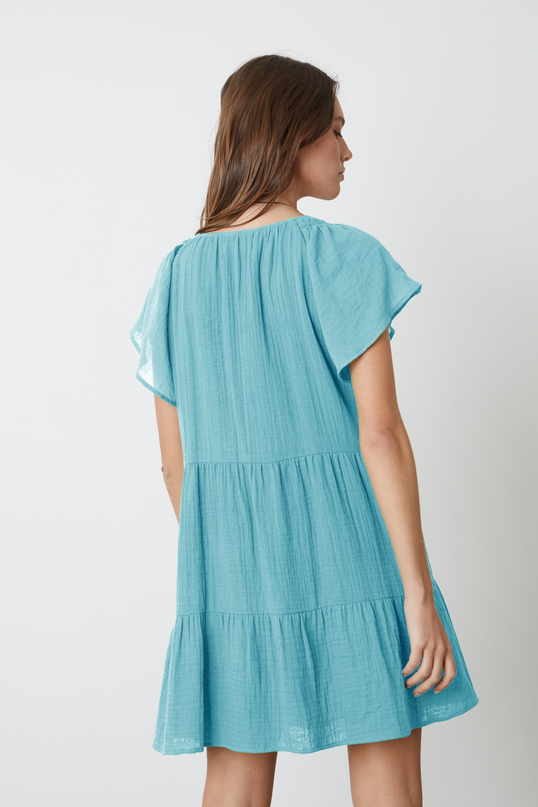   The back view of a woman wearing the Velvet by Graham & Spencer ELEANOR COTTON GAUZE TIERED DRESS. 