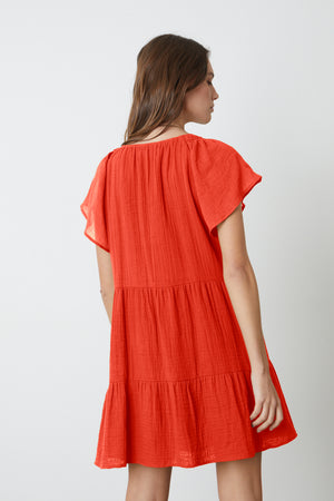 The back view of a woman in an Eleanor Cotton Gauze Tiered Dress by Velvet by Graham & Spencer.