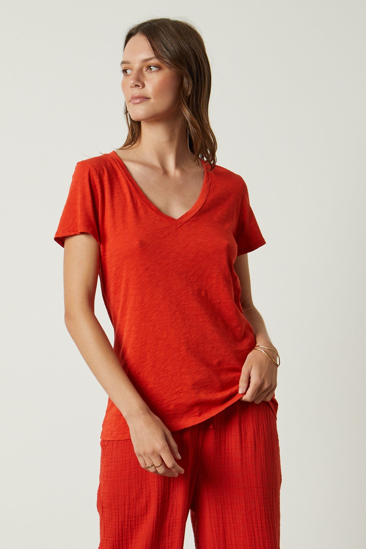 A woman wearing an orange Velvet by Graham & Spencer LILITH COTTON SLUB V-NECK TEE.-26630611140801