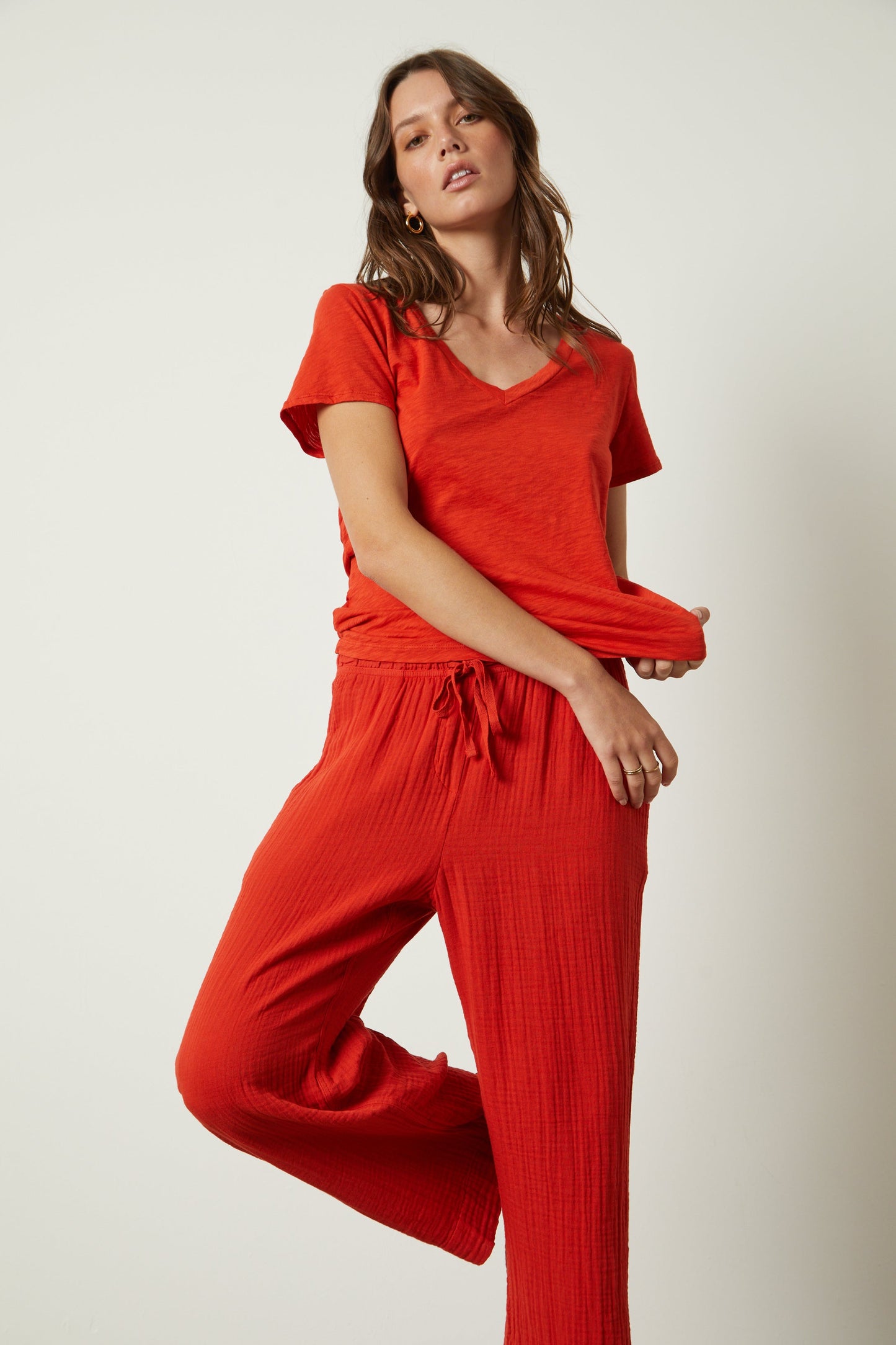 A woman in a LILITH COTTON SLUB V-NECK TEE by Velvet by Graham & Spencer and wide leg pants.-26630611173569
