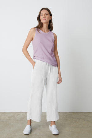 The model is wearing a white Velvet by Graham & Spencer FRANNY COTTON GAUZE PANT and lilac tank top.