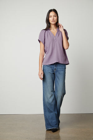 The model is wearing a JADEN COTTON GAUZE V-NECK TOP by Velvet by Graham & Spencer.