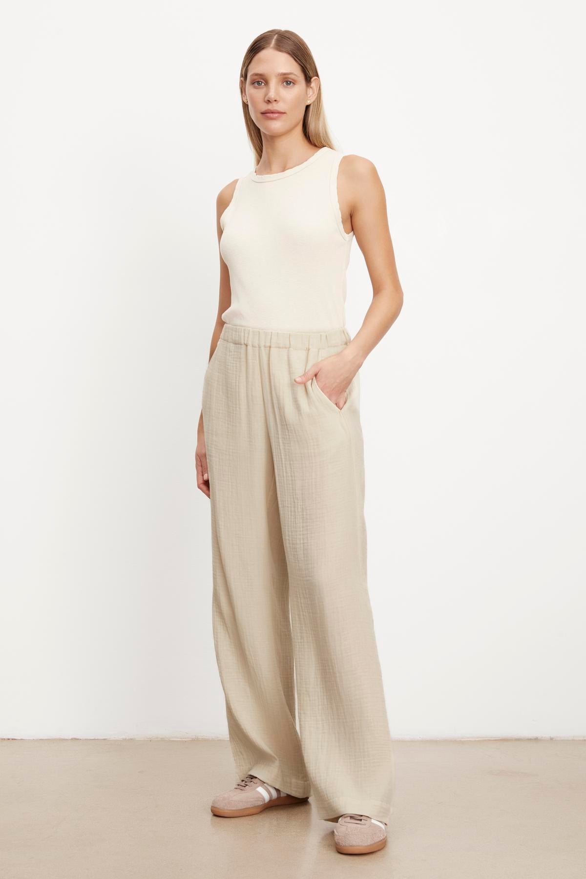 The model is wearing a white tank top and beige JERRY COTTON GAUZE PANT with an elastic waistband by Velvet by Graham & Spencer.-35755555619009