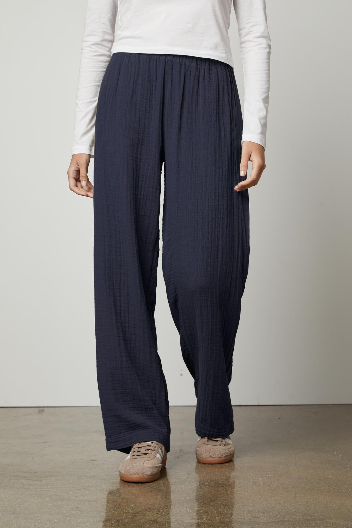 A woman wearing Velvet by Graham & Spencer navy JERRY COTTON GAUZE PANT straight leg pants with an elastic waistband and a white t-shirt.-35660385124545