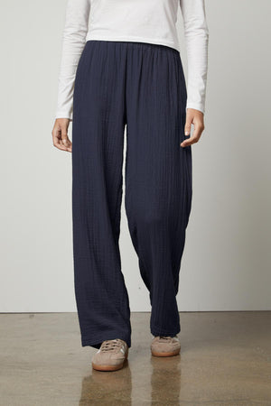 A woman wearing Velvet by Graham & Spencer navy JERRY COTTON GAUZE PANT straight leg pants with an elastic waistband and a white t-shirt.