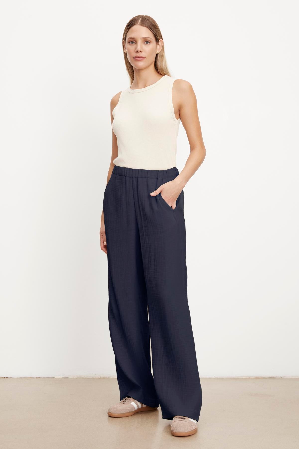 The model is wearing Velvet by Graham & Spencer JERRY COTTON GAUZE PANT navy wide leg trousers with an elastic waistband.-35660385222849