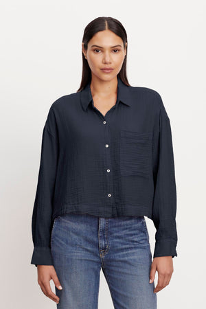 Woman in a casual black LANA COTTON GAUZE BUTTON-UP SHIRT and blue jeans by Velvet by Graham & Spencer.