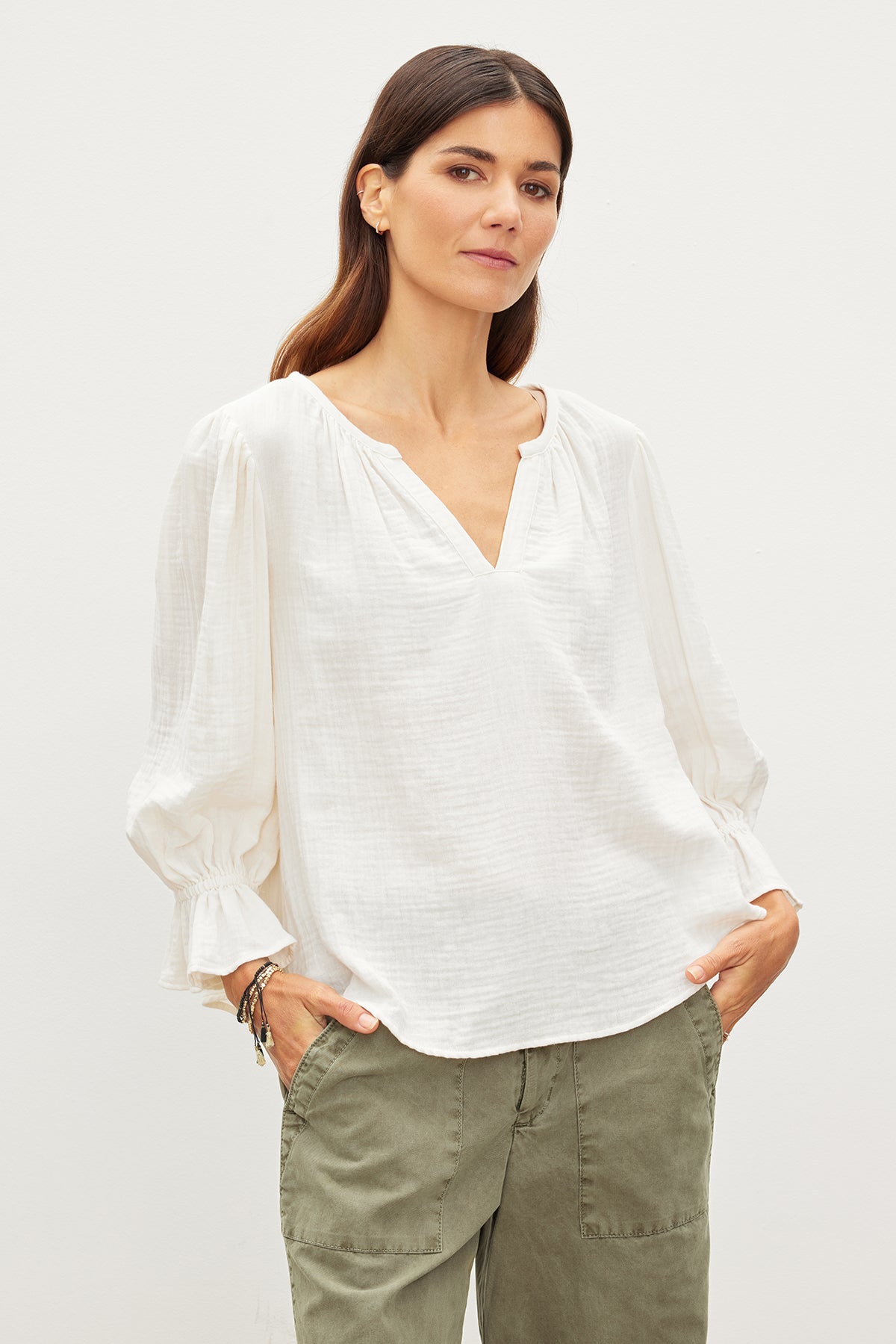   The model is wearing a relaxed fit MILLY COTTON GAUZE PEASANT TOP blouse and green pants made from cotton gauze, achieving effortless sophistication. Brand: Velvet by Graham & Spencer 
