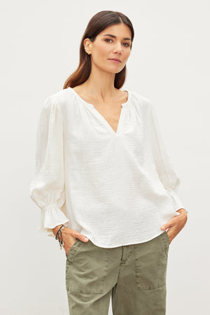 The model is wearing a relaxed fit MILLY COTTON GAUZE PEASANT TOP blouse and green pants made from cotton gauze, achieving effortless sophistication. Brand: Velvet by Graham & Spencer