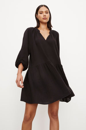 The model is wearing a NICA COTTON GAUZE DRESS by Velvet by Graham & Spencer with ruffled sleeves.