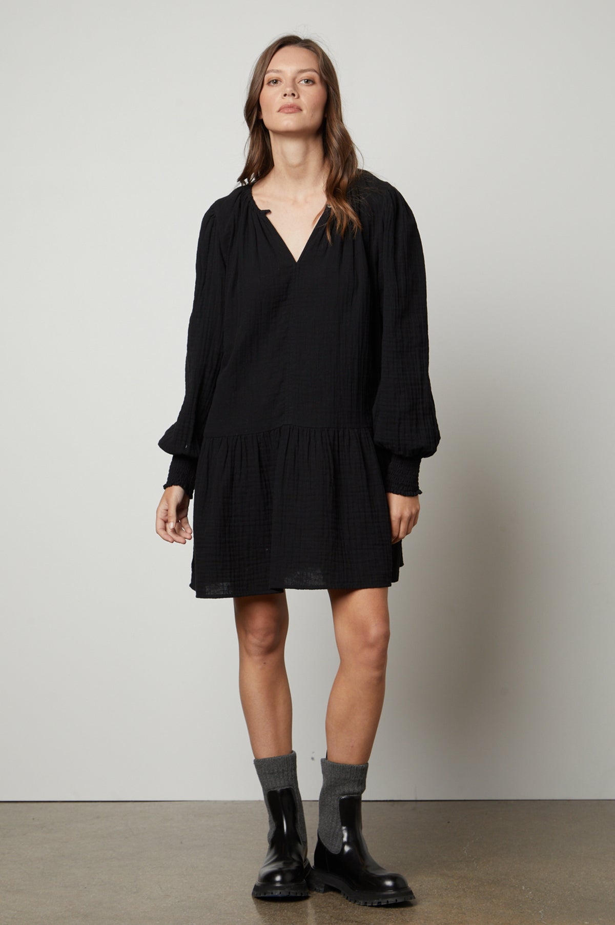   A model wears the VIVIANA COTTON GAUZE DRESS by Velvet by Graham & Spencer, which features a ruffled hem. 