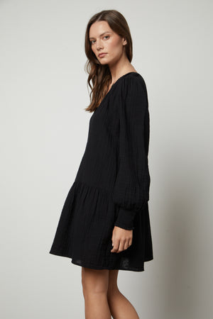 A model wears the Velvet by Graham & Spencer VIVIANA COTTON GAUZE DRESS with ruffled sleeves.