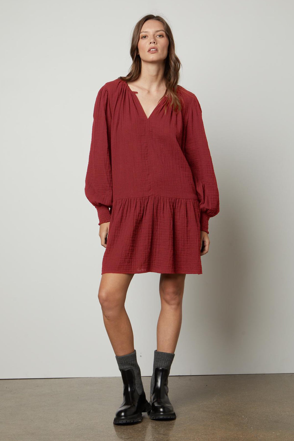   The model is wearing a Velvet by Graham & Spencer VIVIANA COTTON GAUZE DRESS with a v-neckline and long sleeve. 