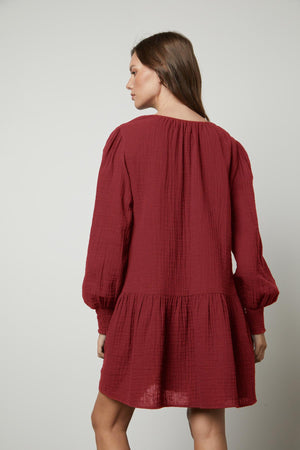The back view of a woman wearing a Velvet by Graham & Spencer VIVIANA COTTON GAUZE DRESS with a v-neckline.