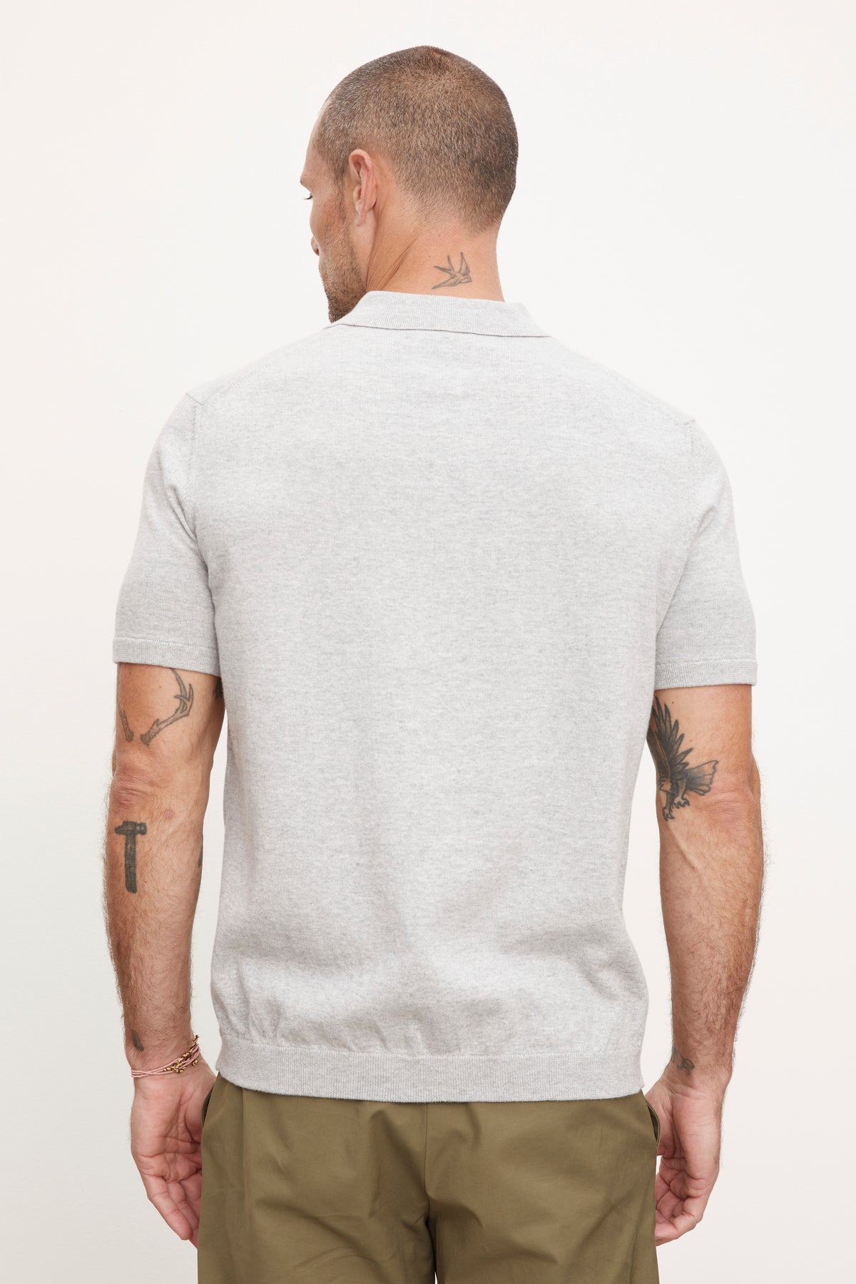   The back view of a man wearing a Velvet by Graham & Spencer OTTO ZIP POLO grey polo shirt. 