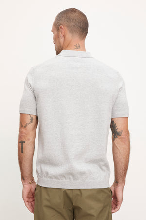 The back view of a man wearing a Velvet by Graham & Spencer OTTO ZIP POLO grey polo shirt.