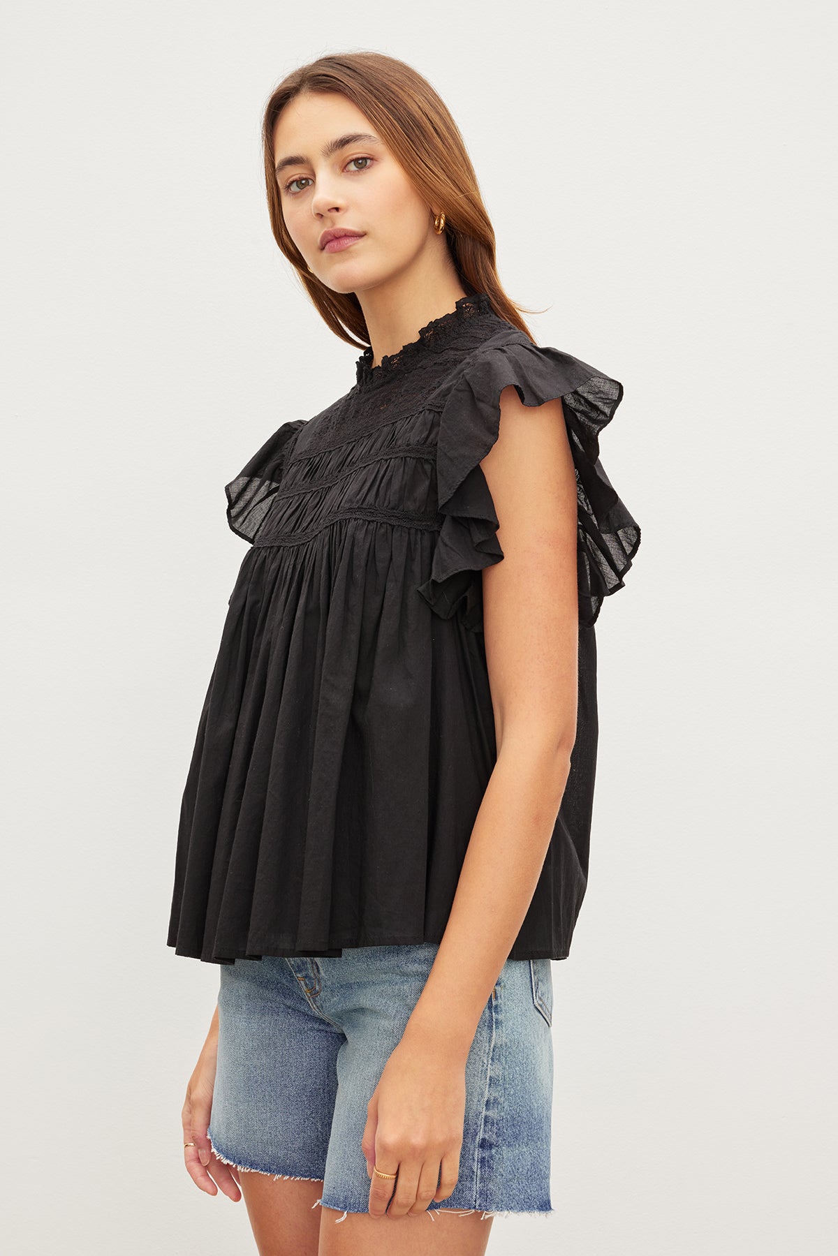   The model is wearing an INESSA COTTON LACE TOP by Velvet by Graham & Spencer with ruffled sleeves. 
