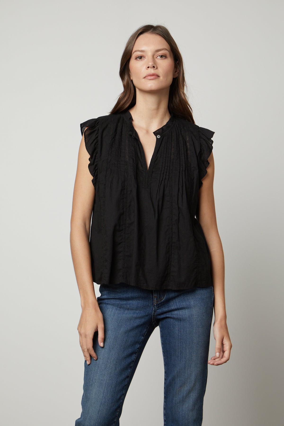   The model is wearing a LIANA LACE TANK TOP by Velvet by Graham & Spencer with ruffled sleeves. 